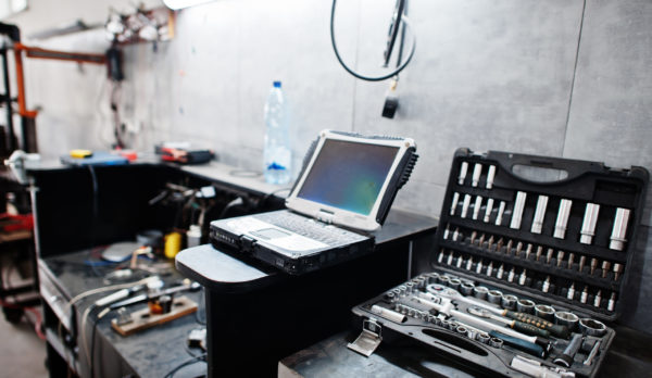 Laptop and tools in maintenance at garage service station.